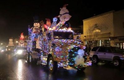 A semi-truck adorned with Christmas decorations leads a parade of similarly adorned trucks A semi-truck adorned with Christmas decorations leads a parade of similarly adorned trucks